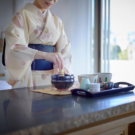 Hotel The Celestine Kyoto Gion Exterior foto A woman in a yukata preparing a Japanese tea ceremony